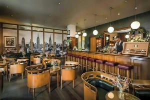 a restaurant with a bar with tables and chairs at Main Plaza Suite Tower in Frankfurt/Main