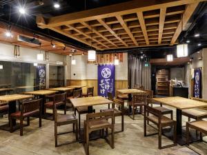 a dining room with wooden tables and chairs at Nishitetsu Inn Shinjuku in Tokyo +102 photos
