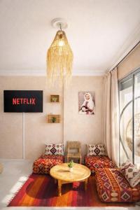 a living room with a couch and a table at 2BR Luxury Apartment-Heart Of Taghazout, Private Beach Access, Panoramic View, Remote Work 100Mbps, Walk to Restaurants in Taghazout