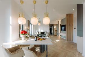 a kitchen and living room with a table and chairs at Luma Central Viewpoint with Private Underground Parking in Târgu-Mureş