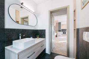 ein Badezimmer mit einem weißen Waschbecken und einem Spiegel in der Unterkunft Luma Central Viewpoint with Private Underground Parking in Târgu Mureș + 25 Fotos