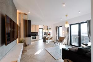 ein Wohnzimmer mit Sofa und Tisch in der Unterkunft Luma Central Viewpoint with Private Underground Parking in Târgu Mureș