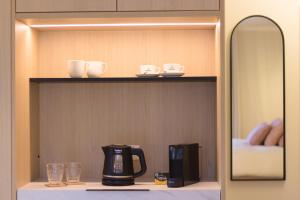 ein Regal mit Kaffeemaschine und Spiegel in der Unterkunft Bed and Breakfast L'Orée Du Bois in Wavre
