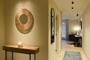 einen Flur mit einem Tisch und einem Spiegel an der Wand in der Unterkunft Bed and Breakfast L'Orée Du Bois in Wavre
