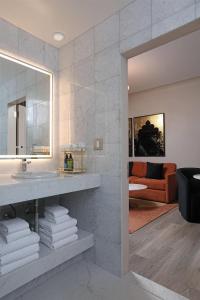 ein Badezimmer mit Waschbecken, Spiegel und Couch in der Unterkunft The Fort Garry Hotel, Spa and Conference Centre, an Ascend Collection Hotel in Winnipeg