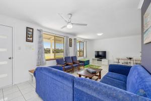 a living room with a blue couch and chairs at Packem Inn in Lancelin
