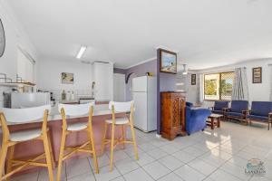 a kitchen and living room with a counter and chairs at Packem Inn in Lancelin