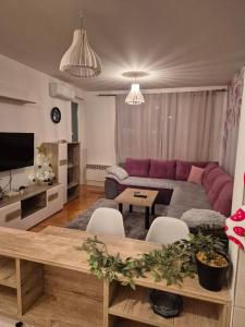 ein Wohnzimmer mit einem lila Sofa und einem Tisch in der Unterkunft Anja in Lukavica