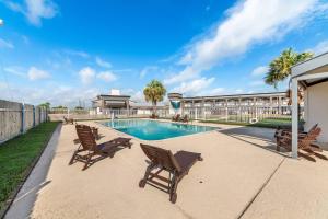 a swimming pool with rocking chairs next to a building at Quality Inn & Suites Port Lavaca near Lighthouse Beach in Port Lavaca