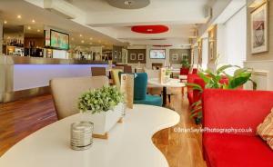 a restaurant with a table and chairs and a bar at The Park Hotel in Liverpool