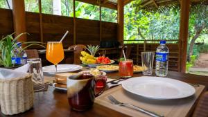 a wooden table with plates of food and drinks on it at Chena Huts Eco Resort in Sigiriya +60 photos