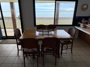 a dining room table and chairs with a view of the ocean at Harrington Haven in Harrington