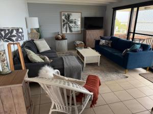 a living room with a blue couch and a chair at Harrington Haven in Harrington