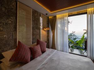a bedroom with a large bed with a large window at Deoja Forest Stay in Darjeeling