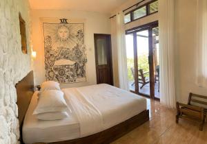 ein Schlafzimmer mit einem Bett mit weißen Laken und Kissen in der Unterkunft Covehill Green Resort in Pelabuhan Ratu + 17 Fotos