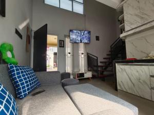 a living room with a couch and a tv at Kira Villa in Tlekung