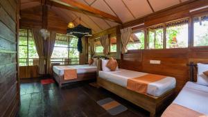 a bedroom with two beds in a room with windows at Chena Huts Eco Resort in Sigiriya