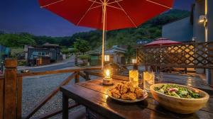 un tavolo con una ciotola di cibo e una ciotola di insalata di Gapyeong Gently Pension a Gapyeong