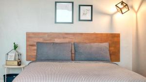 un letto con testiera in legno in una camera da letto di Yeosu Harushimpyo Pension a Yeosu