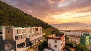 un gruppo di edifici su una collina vicino all'oceano di Yeosu Harushimpyo Pension a Yeosu