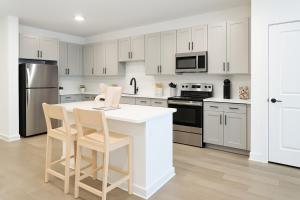 eine Küche mit weißen Schränken und einer weißen Arbeitsplatte in der Unterkunft A plus Location WorkerFriendly KINGbed Pool Gym Modern in Sherman