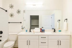 ein weißes Badezimmer mit Toilette und Waschbecken in der Unterkunft A plus Location WorkerFriendly KINGbed Pool Gym Modern in Sherman