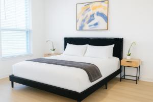 a bedroom with a bed with white sheets and two tables at Modern A plus Location KINGbed pool gym in Sherman
