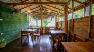 a restaurant with wooden tables and chairs in a room at Chena Huts Eco Resort in Sigiriya