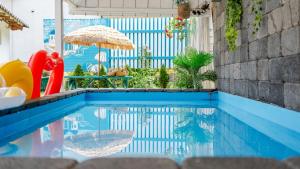 una piscina con sombrilla y sillas y una piscina en Gangneung ggabinejip hanok pension, en Gangneung