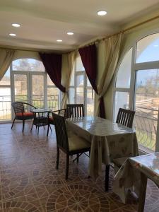 una sala da pranzo con tavoli, sedie e finestre di Sea View villa a Baku