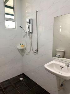 a white bathroom with a shower and a sink at HOMESTAY Mu in Simpang Ampat +16 photos