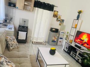 een woonkamer met een bank en een tafel bij Tash Studios in Diani Beach