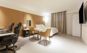 a hotel room with a bed and a table and chairs at 호텔인카페 파주금촌점 in P'aju