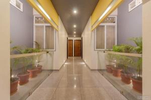 een hal met potplanten in een gebouw bij Hotel Girishankara in Indore