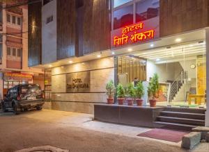 een winkelpui met potplanten ervoor bij Hotel Girishankara in Indore