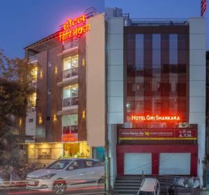 een auto staat geparkeerd voor een hotel bij Hotel Girishankara in Indore