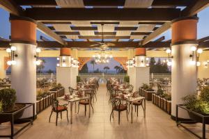 Side Star Resort Hotel - Ultra All Inclusive في سيدي: مطعم به طاولات وكراسي واضاءات