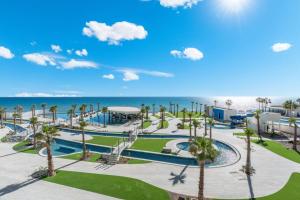 a view of a resort with palm trees and a playground at Encantame Soleil New Resort 3rd Floor Studio in Playa Encanto