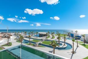 a view of a resort with palm trees and the ocean at Encantame Soleil New Resort 3rd Floor Studio in Playa Encanto