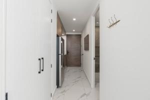 a hallway with white walls and marble floors at Encantame Soleil New Resort 3rd Floor Studio in Playa Encanto +35 photos
