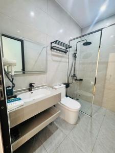 a bathroom with a toilet and a sink and a shower at Homestay Lion in San Cap
