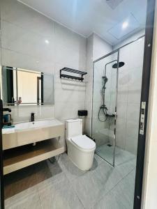 a bathroom with a toilet and a sink and a shower at Homestay Lion in San Cap +2 photos