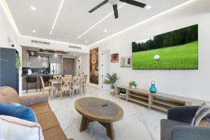 een woonkamer met een tv aan de muur bij Encantmame Soleil 1BR lockoff sleeps 4 in Playa Encanto