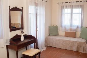 una camera con letto, specchio e tavolo di Oliva Cottage - Ideal for Families Close to Zakynthos Town a Città di Zante