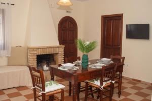 una sala da pranzo con tavolo, sedie e camino di Oliva Cottage - Ideal for Families Close to Zakynthos Town a Città di Zante