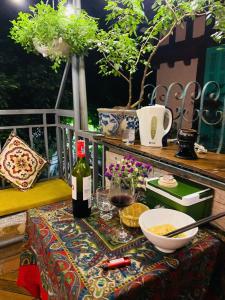 einen Tisch mit einer Flasche Wein und einer Schüssel Essen in der Unterkunft L'e'tage House in Hanoi