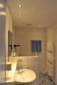 a white bathroom with a sink and a mirror at Gästehaus Wacholderheide Garni in Eimke