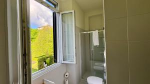 ein Bad mit einem Fenster, einem WC und einer Dusche in der Unterkunft AxelParkComo in Como + 86 Fotos