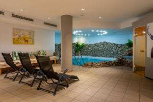 a room with chairs and a stone wall at Hotel zum Hirschen Zell am See in Zell am See