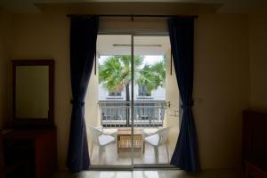 a room with a window with a table and chairs at Ashiraya hostel in Kata Beach